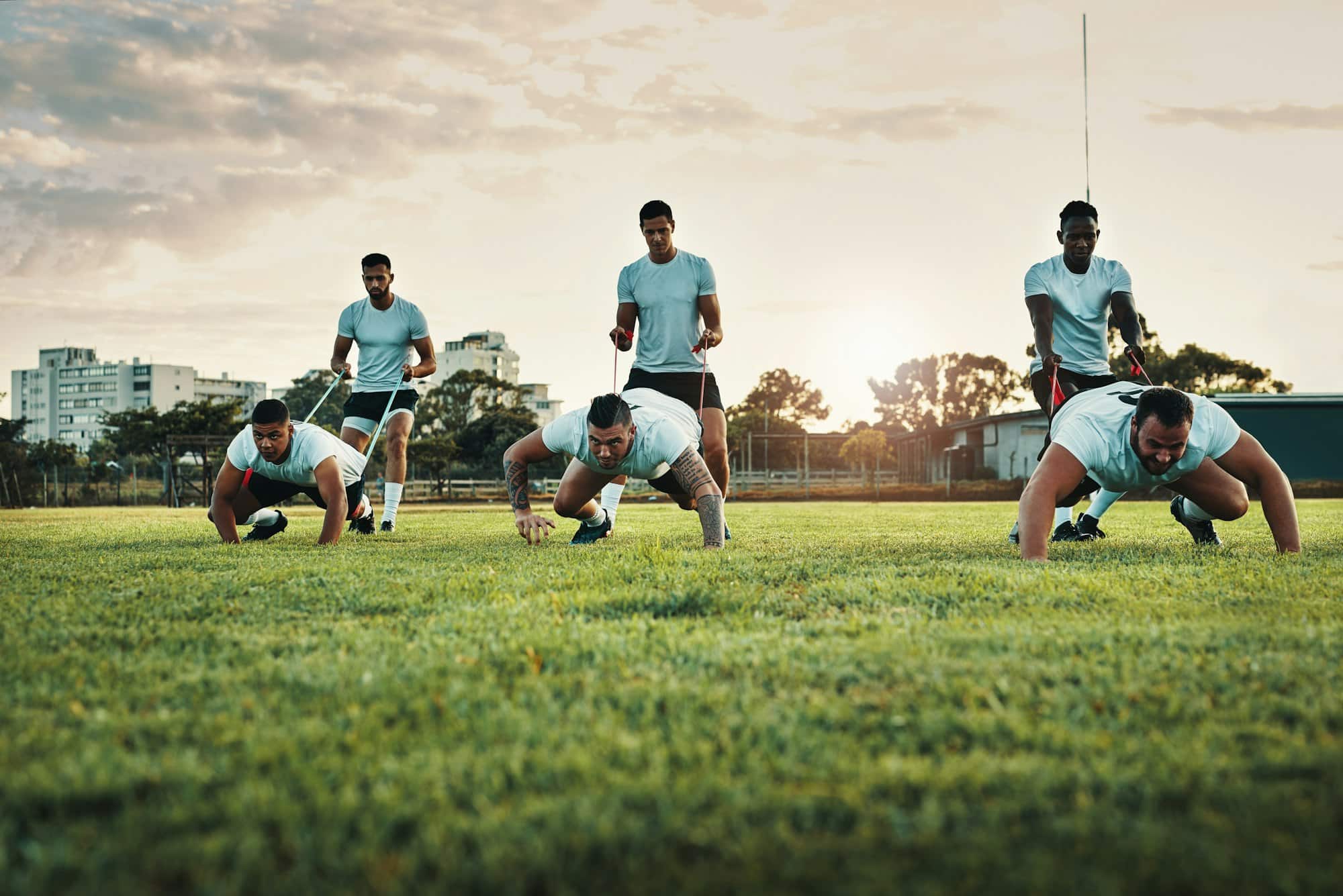 Full length shot of a group of young rugby players training with bands on the field during the day