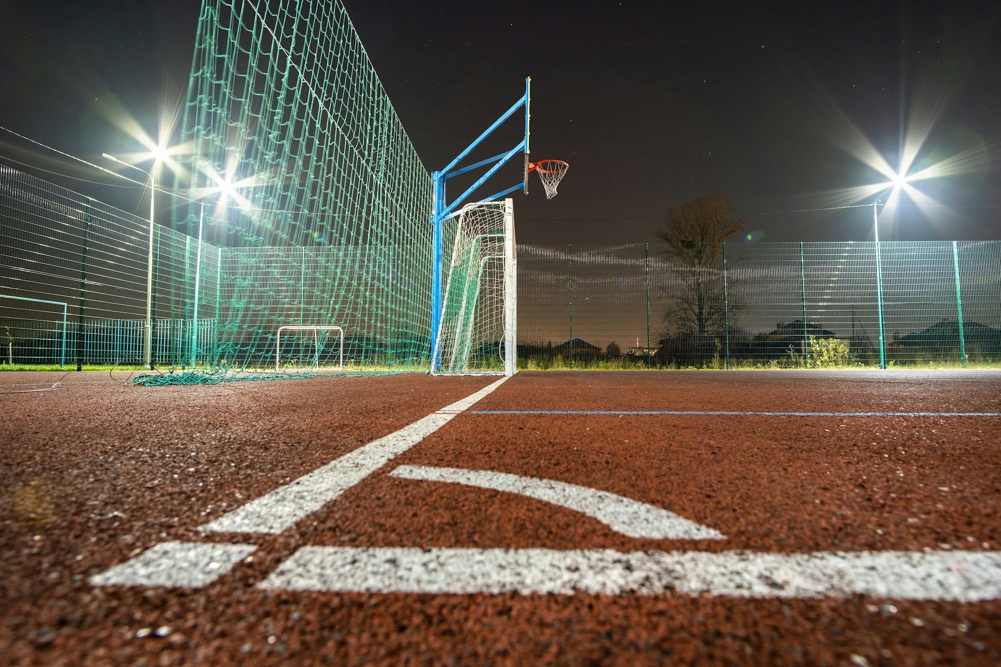 Outdoors mini football and basketball court with ball gate and basket surrounded with high