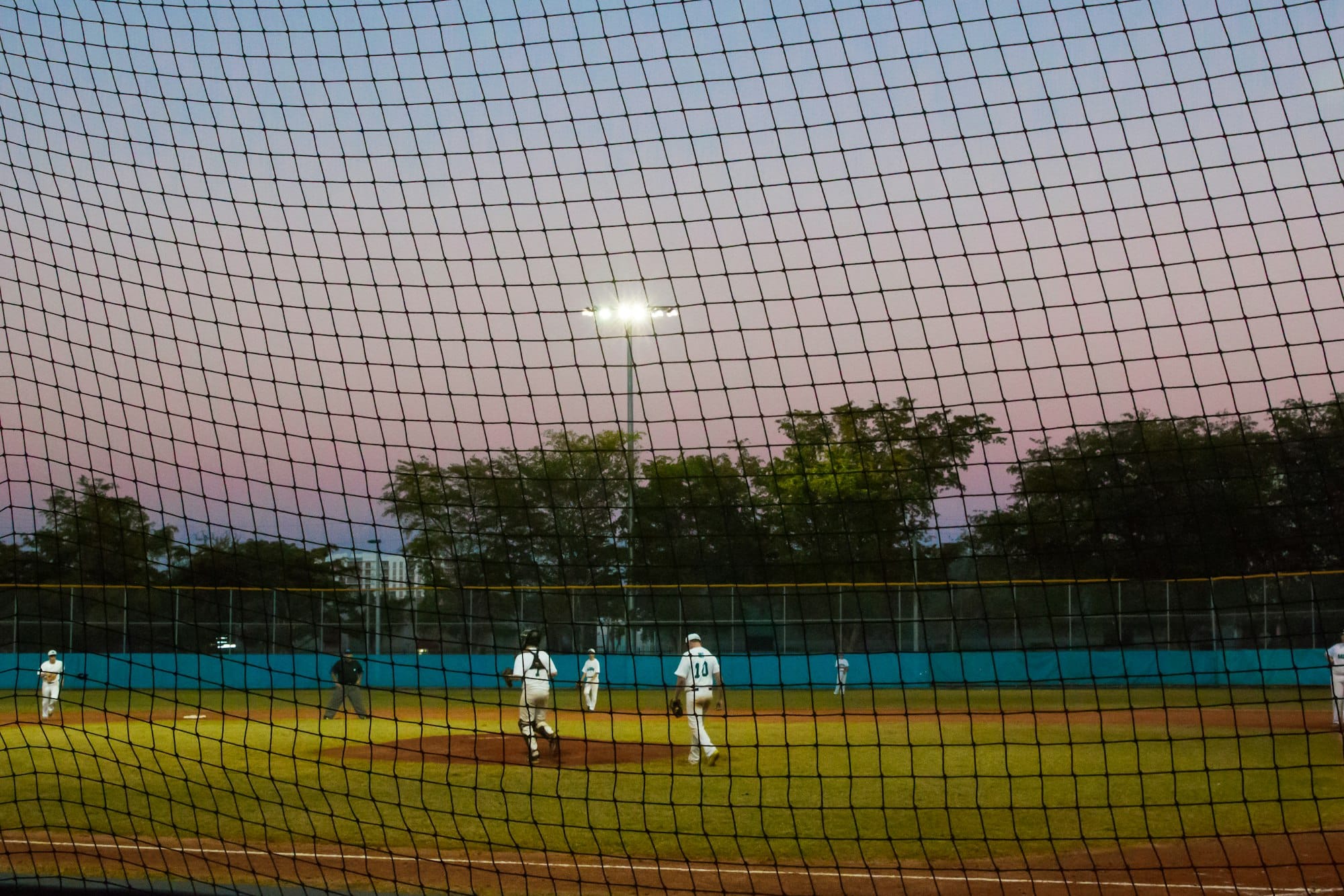 Sunset over high school kids on a baseball field playing in a game